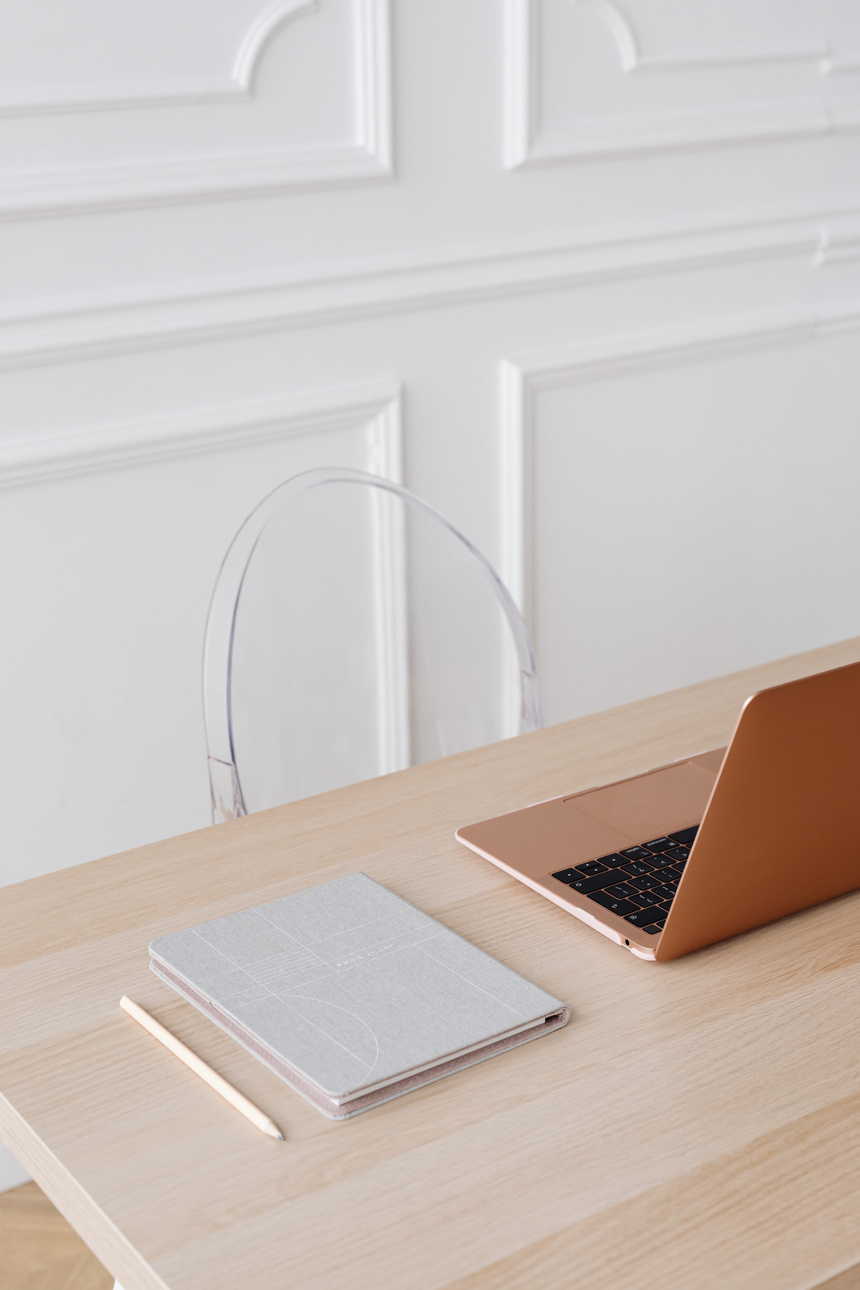 A Laptop and Notebook on a Wooden Table